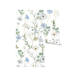 A rolled section of the Florist Wallpaper - 75", showcasing the intricate floral design with a blend of soft blue blossoms and green leaves on a bright white background, ideal for adding a fresh and vibrant touch to any interior.