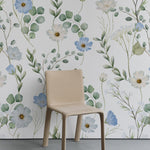 A contemporary room featuring the Florist Wallpaper - 75" on the wall behind a beige chair, highlighting the wallpaper’s detailed floral patterns in soft blues and whites that create a calm, elegant atmosphere