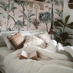 Cozy bedroom decorated with Exotic Tropical Wallpaper showcasing palm trees and tropical plants, enhancing a relaxing ambiance.