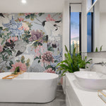 Modern bathroom interior showcasing a wall adorned with Kyoto Dreams wallpaper. The pattern features intricate depictions of cranes, peonies, and Asian architectural elements, creating a tranquil and decorative backdrop for the sleek white bathtub and vanity