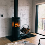 A stylish interior showcasing the winter wildlife wallpaper with its detailed sketches of forest animals and snow-covered landscapes, adding a serene and rustic charm to the room, complemented by a modern wood-burning stove.
