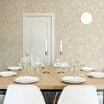A modern dining room featuring the Ecru Floral Sketch Wallpaper - 25". The wallpaper, with its subtle beige floral sketches on an ecru background, adds an understated elegance to the space, complemented by the simple white chairs, wooden table, and minimalist decor.