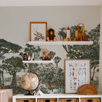 A well-organized nursery featuring safari-themed wallpaper with trees and wildlife. Above a white crib, floating shelves display children's toys and books. A storage unit with wicker baskets stands beneath, and a soft white fur rug lies on the wooden floo