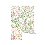 A rolled-up piece of Watercolour Floral and Leaf Wallpaper II, revealing a vibrant mix of watercolor flowers and leaves in pastel hues, ideal for adding a natural and artistic touch to any room.