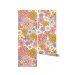A roll of Retro Groovy Flower Wallpaper showcasing a vibrant mix of large, colorful flowers in retro styles, perfect for adding a bold and cheerful touch to any space