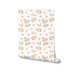 Roll of Organic Peach Wallpaper showcasing the delightful design of watercolor peaches, leaves, and pink flowers on a white background