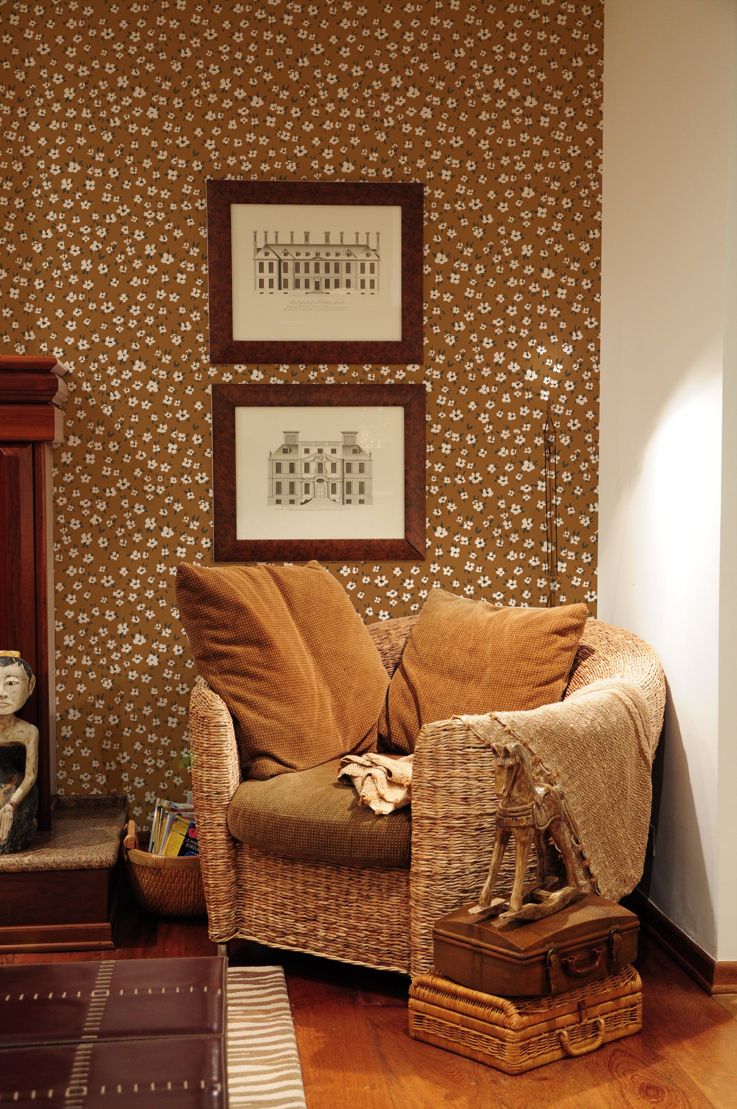 A stylish hallway featuring a brown leather chair against a wall covered in brown wallpaper with a white floral pattern, above white wainscoting, with a white deer head sculpture and coat rack