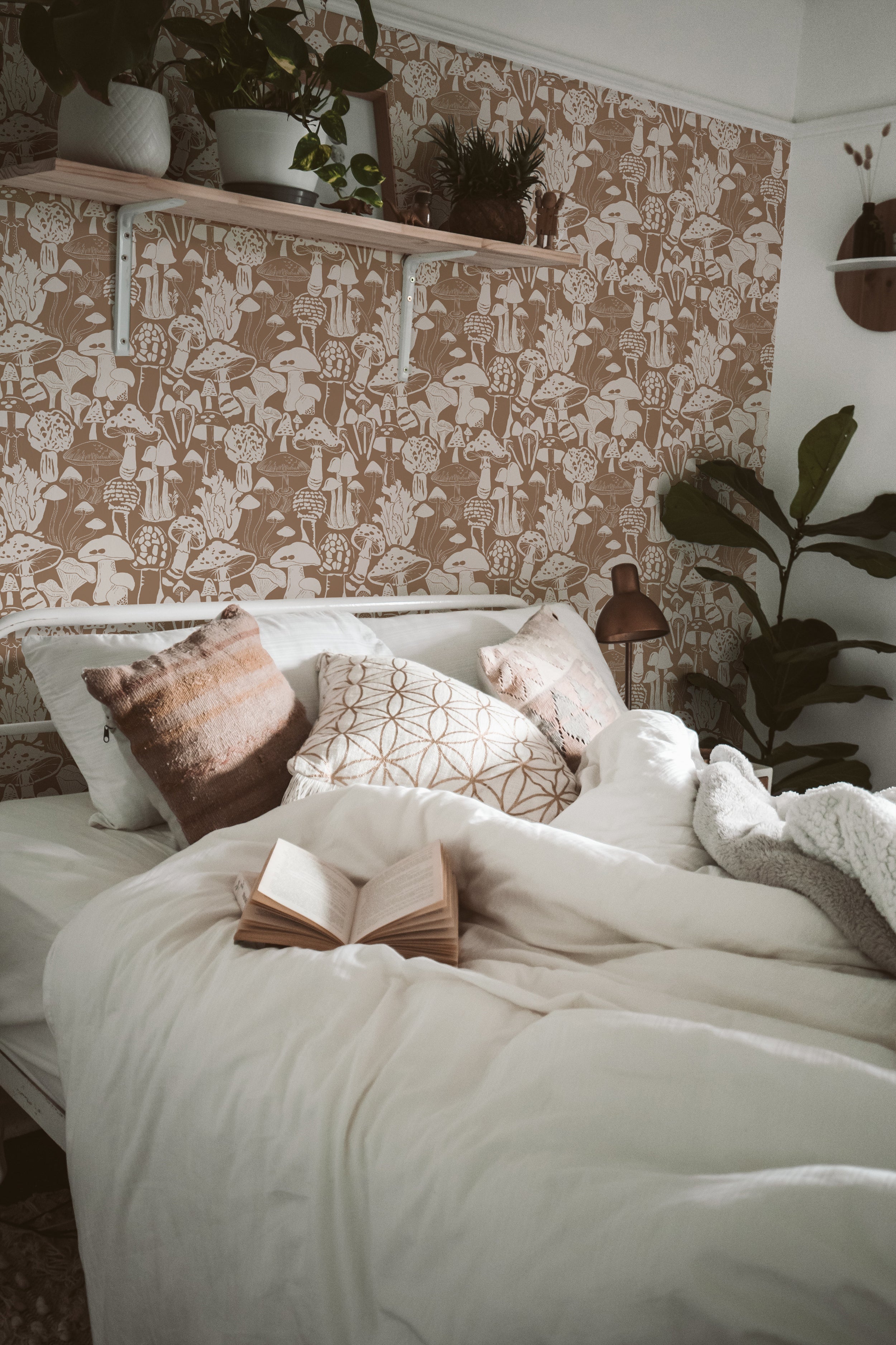 A tranquil bedroom featuring a wall adorned with a whimsical mushroom-patterned wallpaper in shades of brown and cream, creating a nature-inspired retreat, complemented by houseplants and cozy bedding.