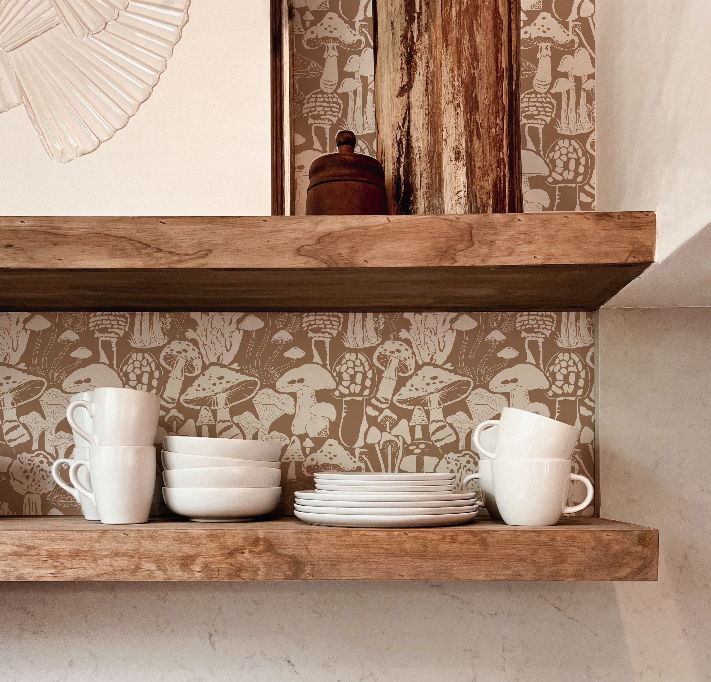 A rustic kitchen shelf scene set against a charming mushroom-patterned wallpaper in brown, showcasing an assortment of white cups and dishes, invoking an earthy and homey ambiance.