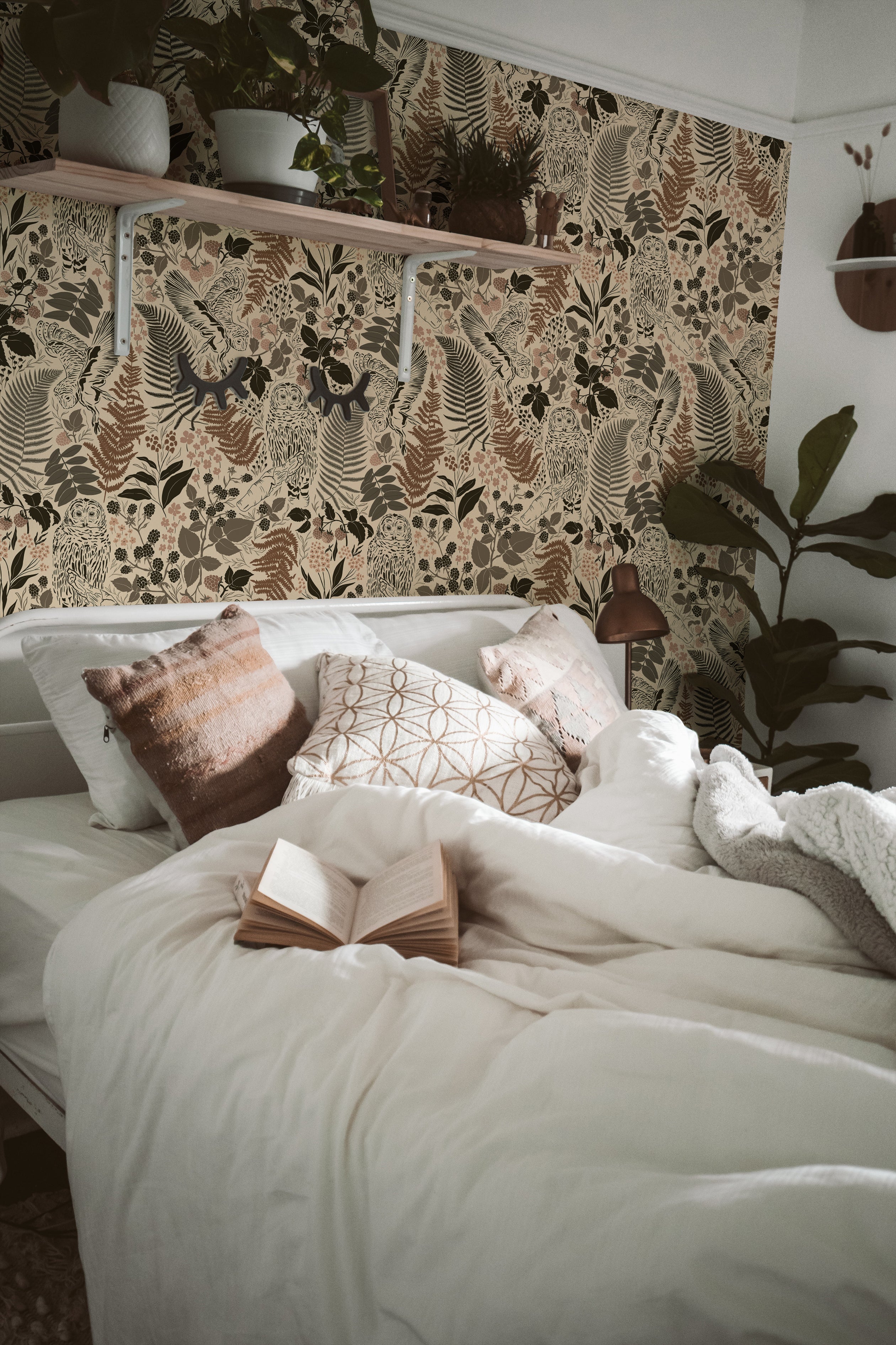 A serene bedroom with a wall covered in an owl and botanical pattern wallpaper, combining taupe, beige, and black hues, complemented by indoor plants and a cozy, well-dressed bed.