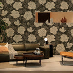 Modern living room featuring a large, elegant floral wallpaper with cream roses on a dark gray background. The space includes a dark leather sofa, designer chairs, and wood accent furniture, creating a sophisticated and inviting atmosphere.