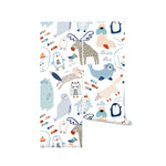 A close-up view of a roll of "Nordic Moose Wallpaper" showcasing a colorful and whimsical pattern of various Nordic animals like winged moose, owls, seals, and foxes in playful poses on a light background.