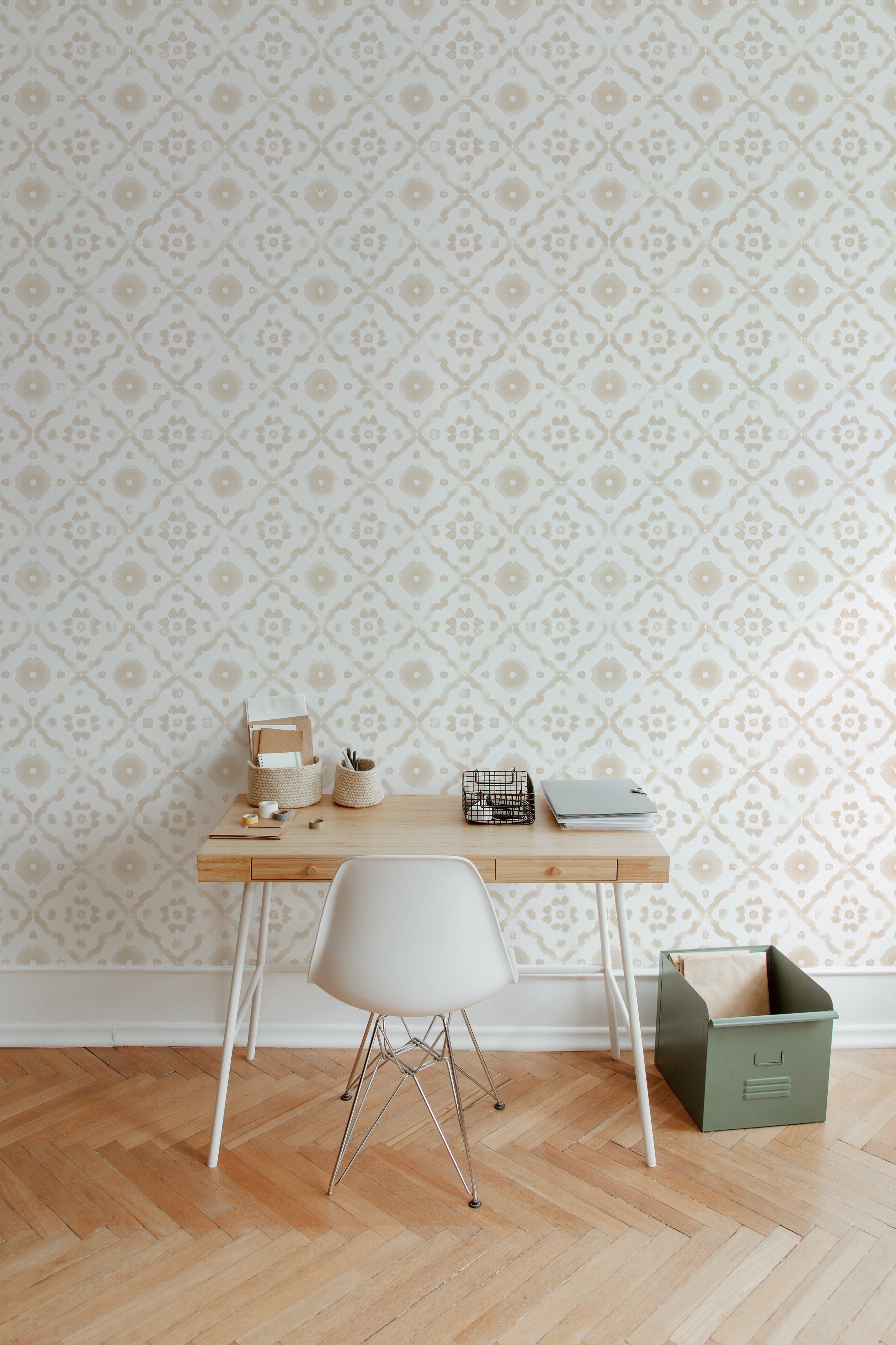 A minimalistic home office setup featuring Euclid Wallpaper with a subtle geometric pattern of cream motifs on a light beige background. The workspace includes a wooden desk, a modern white chair, and various office supplies neatly organized, creating a serene and productive environment.