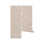 A roll of Linen Color Burn Wallpaper, showcasing its beautiful floral rose design in a soft beige palette. The wallpaper roll is displayed vertically, emphasizing the delicate and intricate pattern