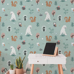 An office space is transformed with "Kids Wallpaper - Forest Critters - 25 inches" on one wall, providing a whimsical backdrop. The scene includes playful bears, friendly owls, and lively squirrels amongst an array of trees and plants, enhancing the creative and tranquil atmosphere of the room.
