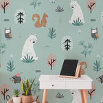 A workspace is transformed with the "Kids Wallpaper - Forest Critters - 50 inches," providing a calming backdrop. The wallpaper features large images of forest animals like bears and owls among trees and plants, enhancing the creative and peaceful atmosphere of the room.