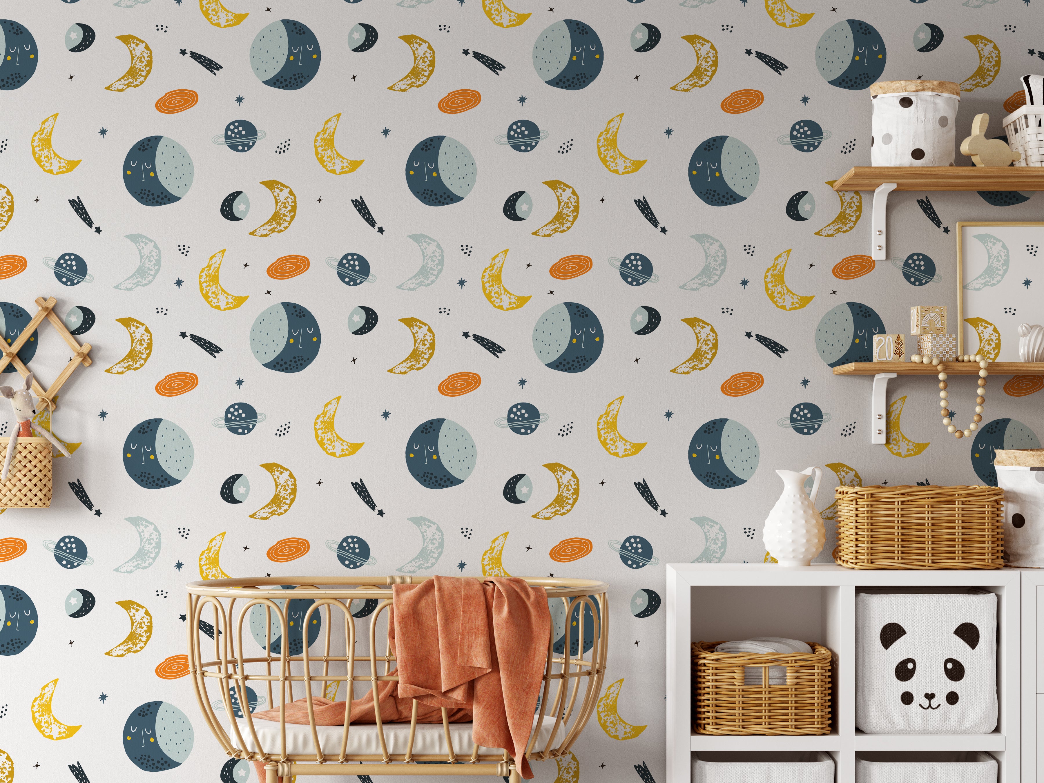 A cozy nursery featuring a wall adorned with a celestial-themed wallpaper. The wallpaper includes playful illustrations of moons, stars, planets, and comets, creating a dreamy and serene atmosphere. The room is furnished with a wicker crib, shelves, and storage baskets.
