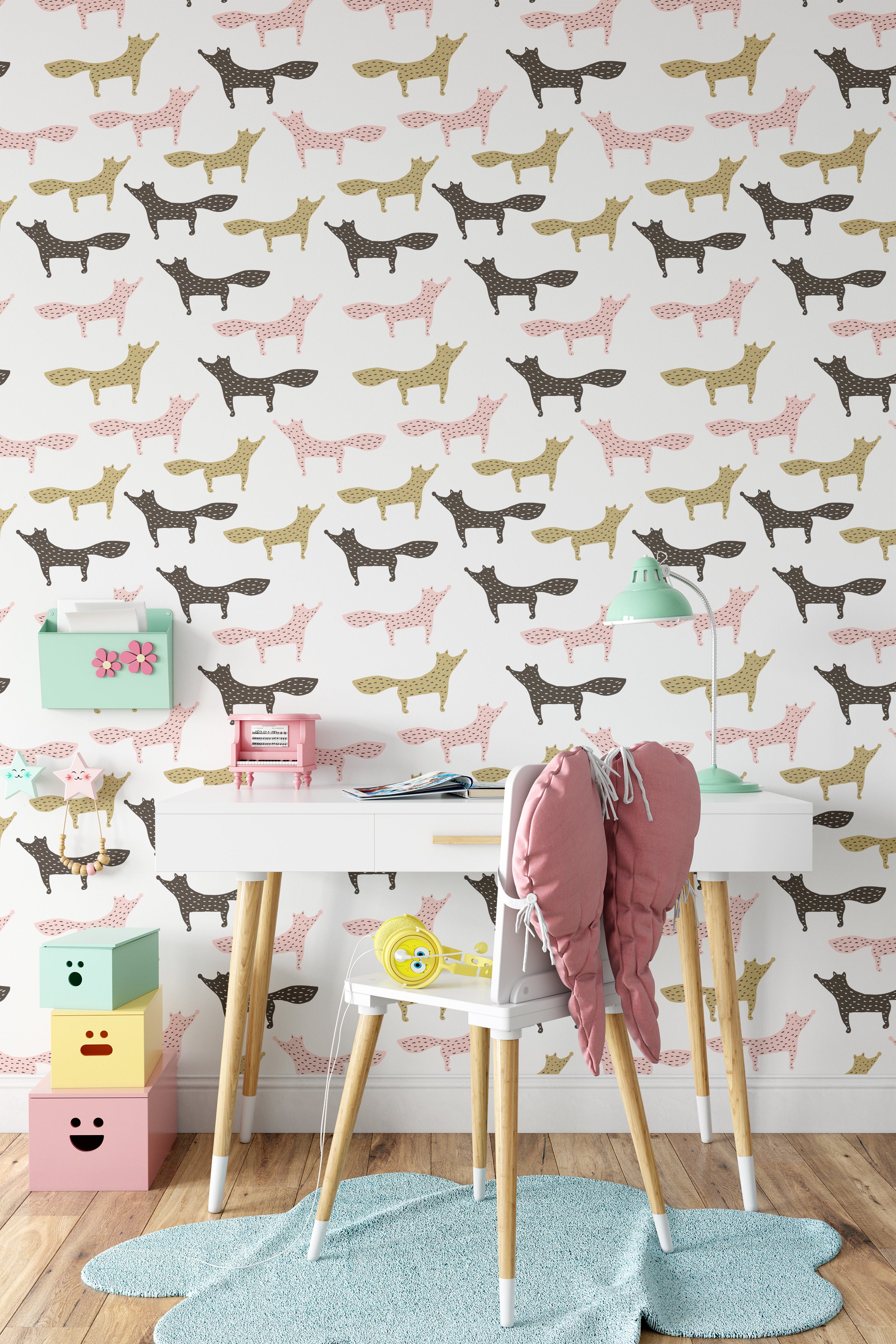 Interior view of a child's workspace with walls adorned by the Foxes Wallpaper. The room features a variety of playful fox figures in soft pink, mustard yellow, and black, contributing to a vibrant and stimulating environment for creativity and learning