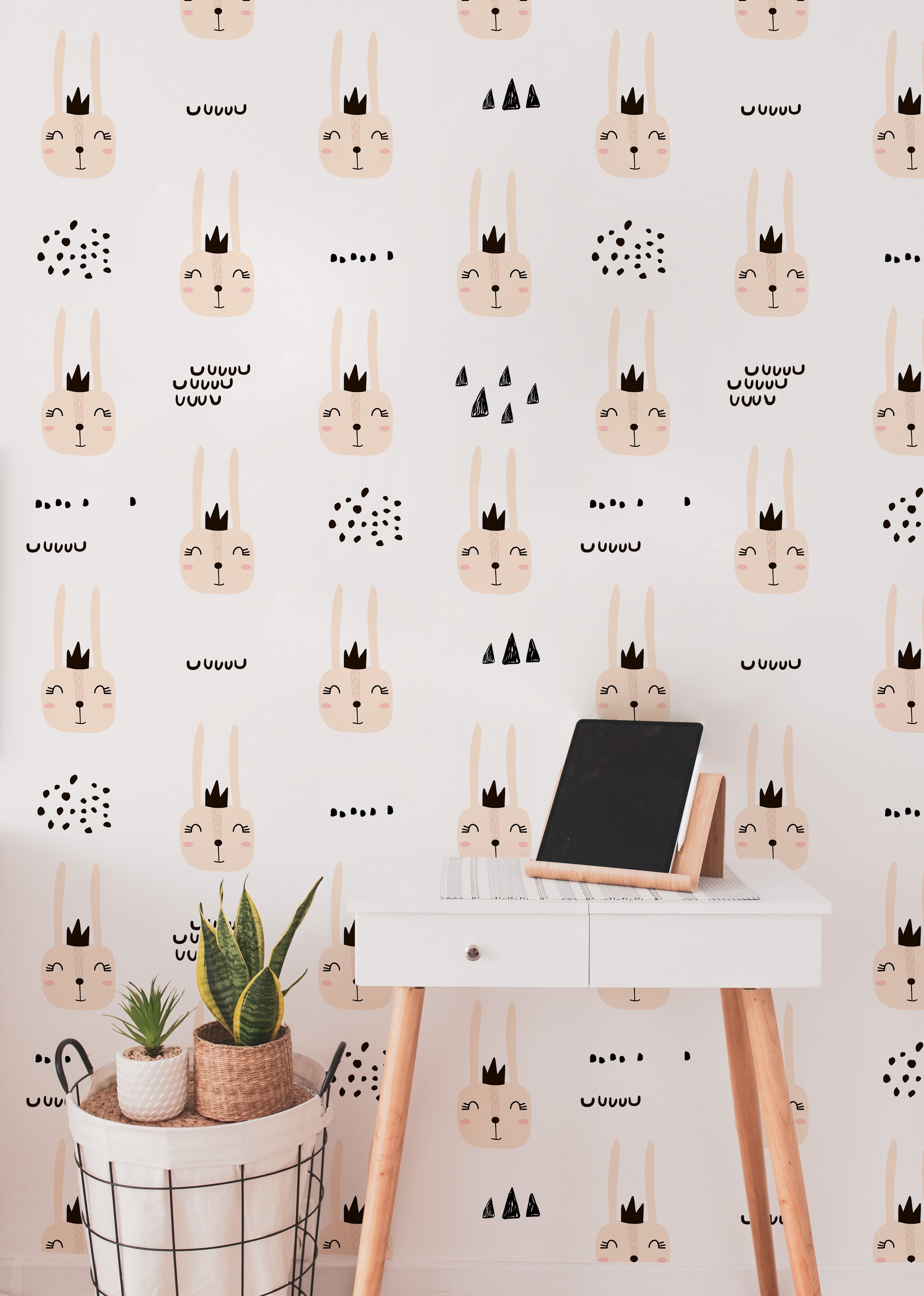 An interior setup displaying the Cute Bunnies Wallpaper in a home office space. The wallpaper, filled with endearing bunny faces and simple decorative motifs, covers the room, adding a charming and whimsical atmosphere suitable for creative or child-friendly spaces