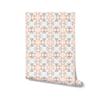 Sample roll of Moroccan Dream Tile Wallpaper II, displaying its intricate geometric pattern inspired by traditional Moroccan tiles in shades of orange and gray, perfect for adding a touch of elegance to any room.