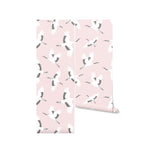 Roll of 'Kids Crane Wallpaper' displaying a repeating pattern of elegant white cranes in flight on a soft pink background, perfect for adding a touch of grace and calm to any child’s room.