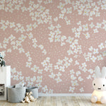 A vibrant children's play area where the Fleur de Printemps Wallpaper adds a whimsical touch with its large white flowers and dotted design on a gentle pink background, perfect for sparking imagination.