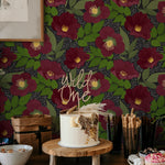 A festive dessert table set against the Merlot Floral Wallpaper, which adds a lively and elegant backdrop with its oversized dark red flowers and lush greenery. The scene is perfect for celebrations, accentuating the color and joy of the occasion.