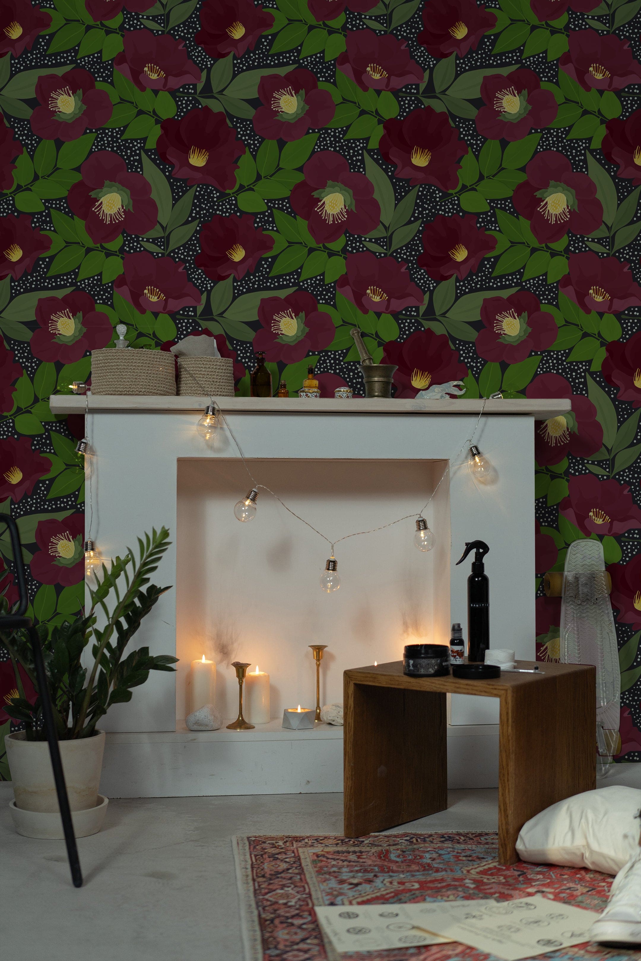 A cozy living space enhanced by the Merlot Floral Wallpaper, featuring large merlot-colored flowers with bright yellow centers, set against a dark background peppered with subtle polka dots. The room is warmly lit by string lights, creating a soothing atmosphere.