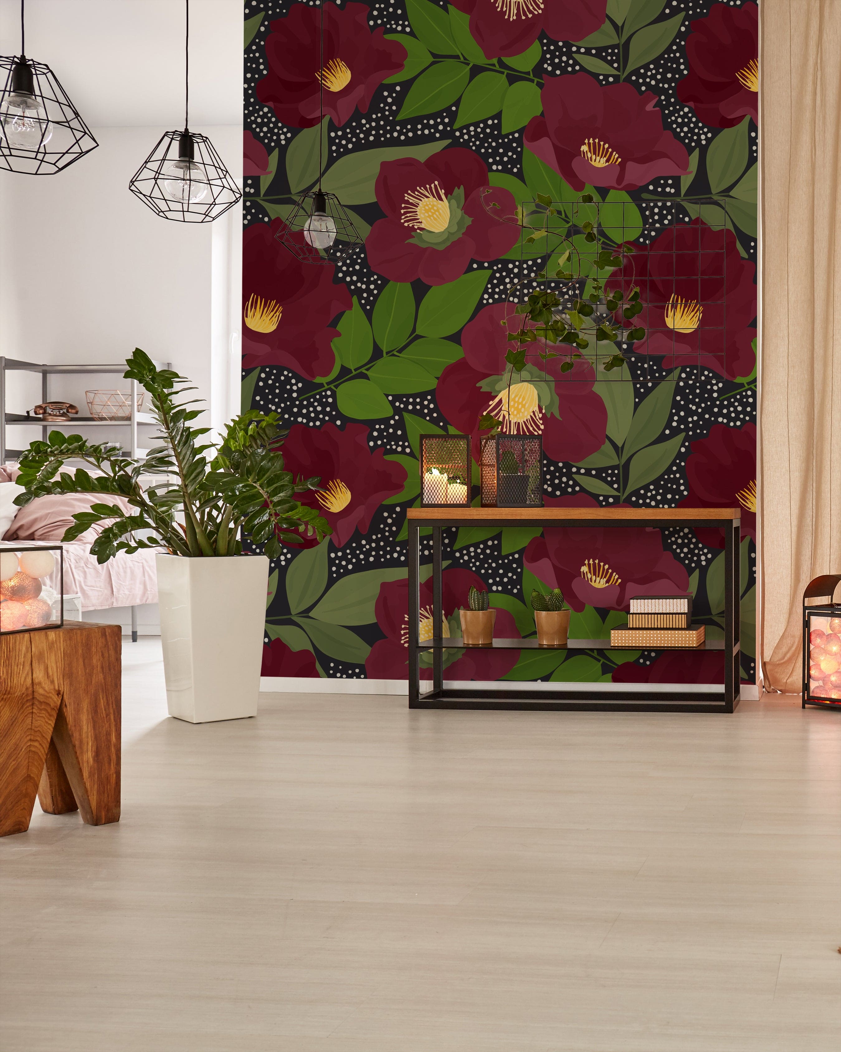 A modern interior space featuring the Merlot Floral Wallpaper, which showcases large, dark red flowers with vibrant green leaves on a dotted black background. The room is styled with contemporary furniture and green houseplants, creating a bold yet inviting atmosphere.