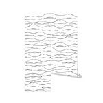 An innovative decorative room divider, showcasing a wallpaper with a repetitive pattern of black abstract line drawings on a white background. The divider consists of two panels connected by hinges, featuring the stylish and simplistic design that blends seamlessly into a contemporary decor.