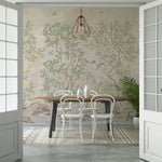 Image of a dining area where chinoiserie wallpaper serves as a backdrop to a simple, yet elegant setting with a wooden dining table, white chairs, and a geometric pendant light, offering a subtle infusion of nature into the space