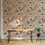 Modern dining space with a minimalist table against a wall covered in floral wallpaper with peach blossoms and green foliage
