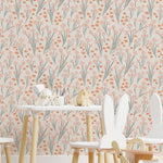 A vibrant and cheerful children's playroom features walls covered with the orange and pink floral wallpaper. The space is furnished with a white table, whimsical animal-shaped chairs, and wooden toys, creating a playful and inviting atmosphere.