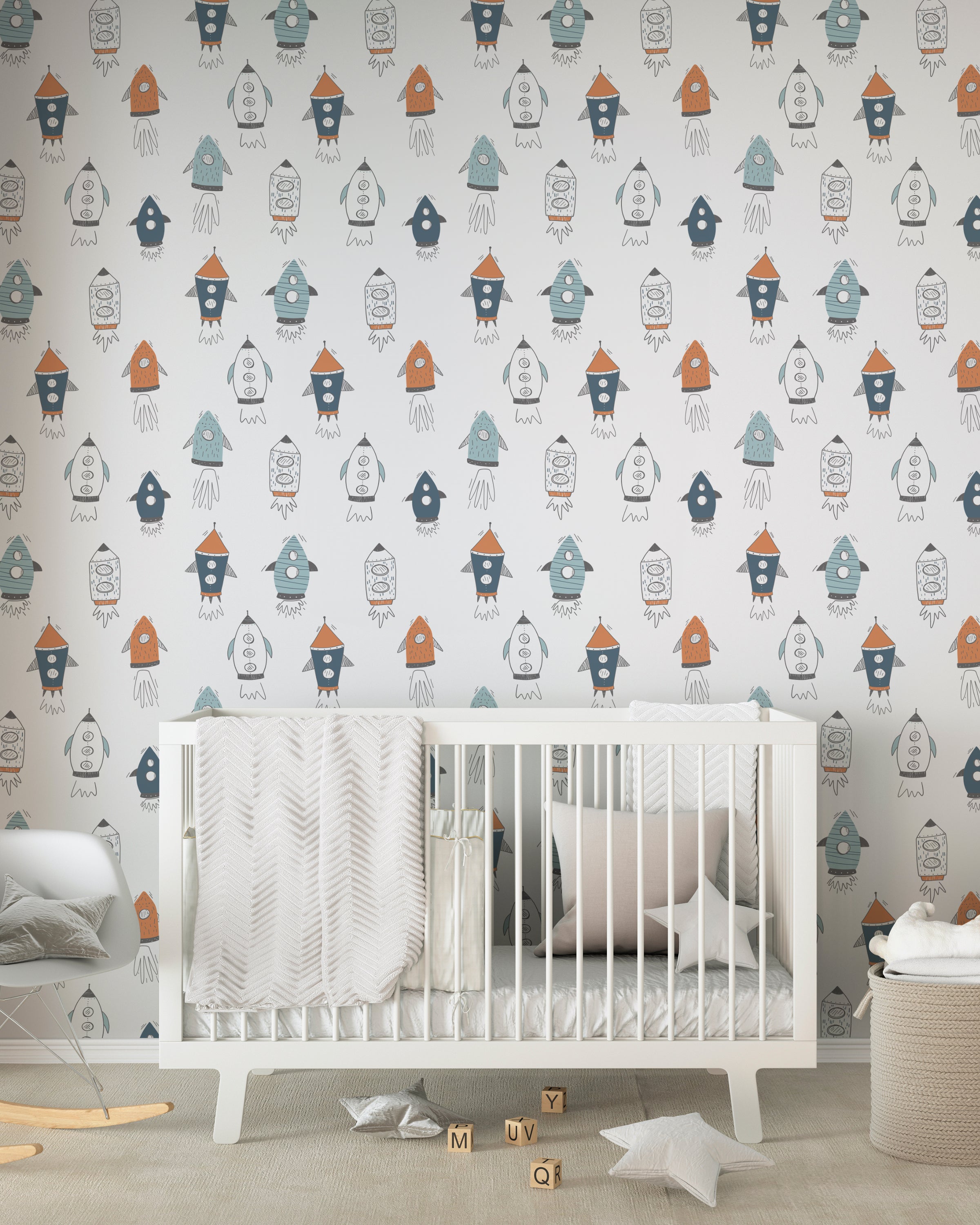 Corner of a nursery with space-themed wallpaper filled with colorful rockets, complementing a white crib and neutral room decor