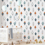 Nursery room with walls covered in rocket-themed wallpaper, accented by light blue balloons, white crib, and plush carpet