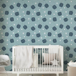 "Nursery room decorated with 'Starlit Planets' wallpaper displaying a calming pattern of navy planets and stars, paired with a white crib and soft bedding."