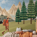 "Illustrative wallpaper mural in a children's room depicting two hikers walking through a stylized forest with towering mountains in the background.