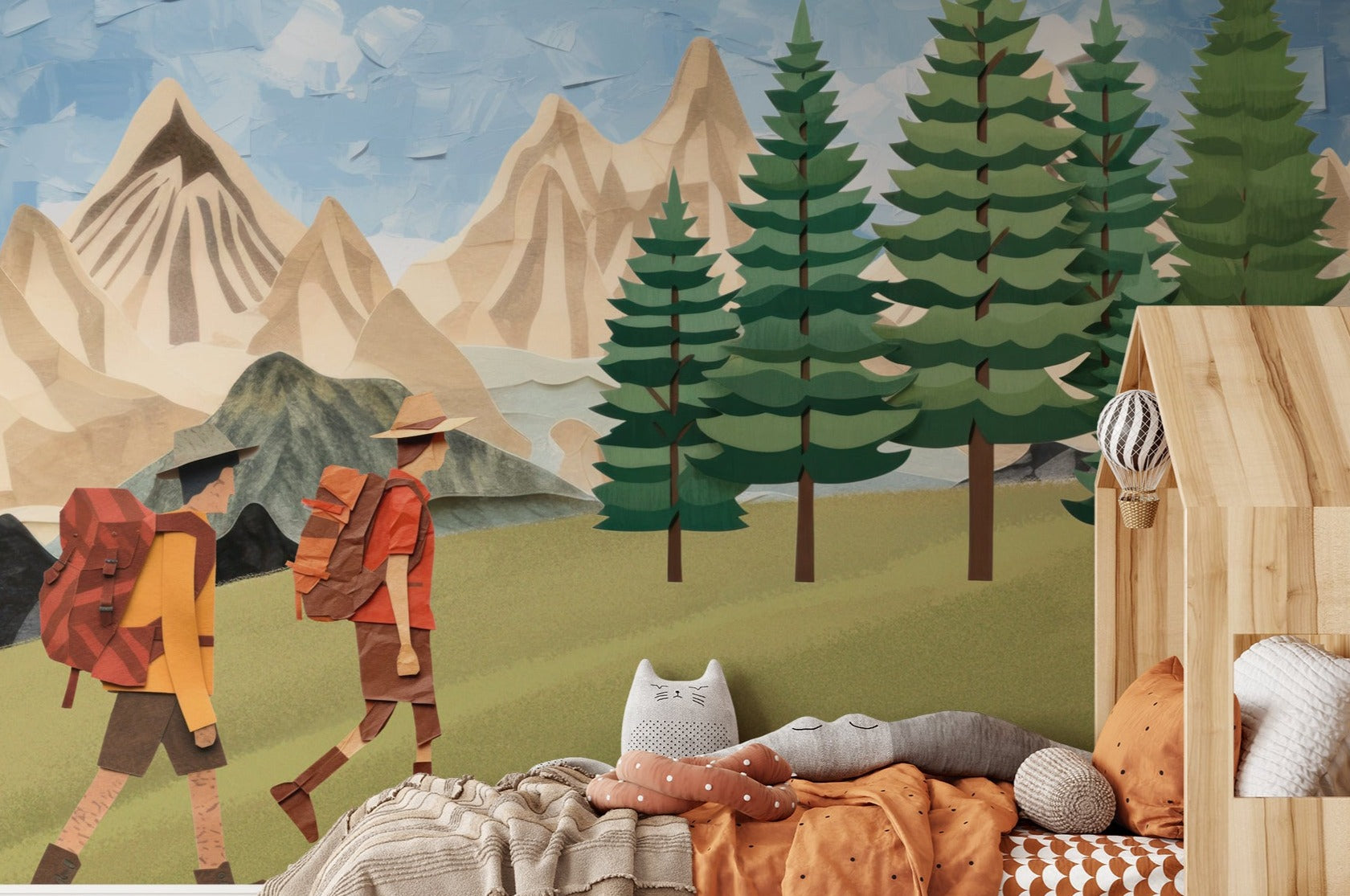 "Illustrative wallpaper mural in a children's room depicting two hikers walking through a stylized forest with towering mountains in the background.