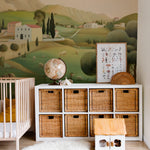 Nursery room showcasing a pastoral landscape mural with a crib, wicker storage baskets, and a plush white rug.