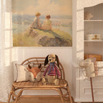 Children's playroom featuring pastel river bend mural with plush toys on rattan bench