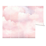 A single roll of Pink Cloud Mural wallpaper, unrolled to reveal a continuous design of fluffy pink and white clouds, perfect for creating a whimsical and serene atmosphere in any room.