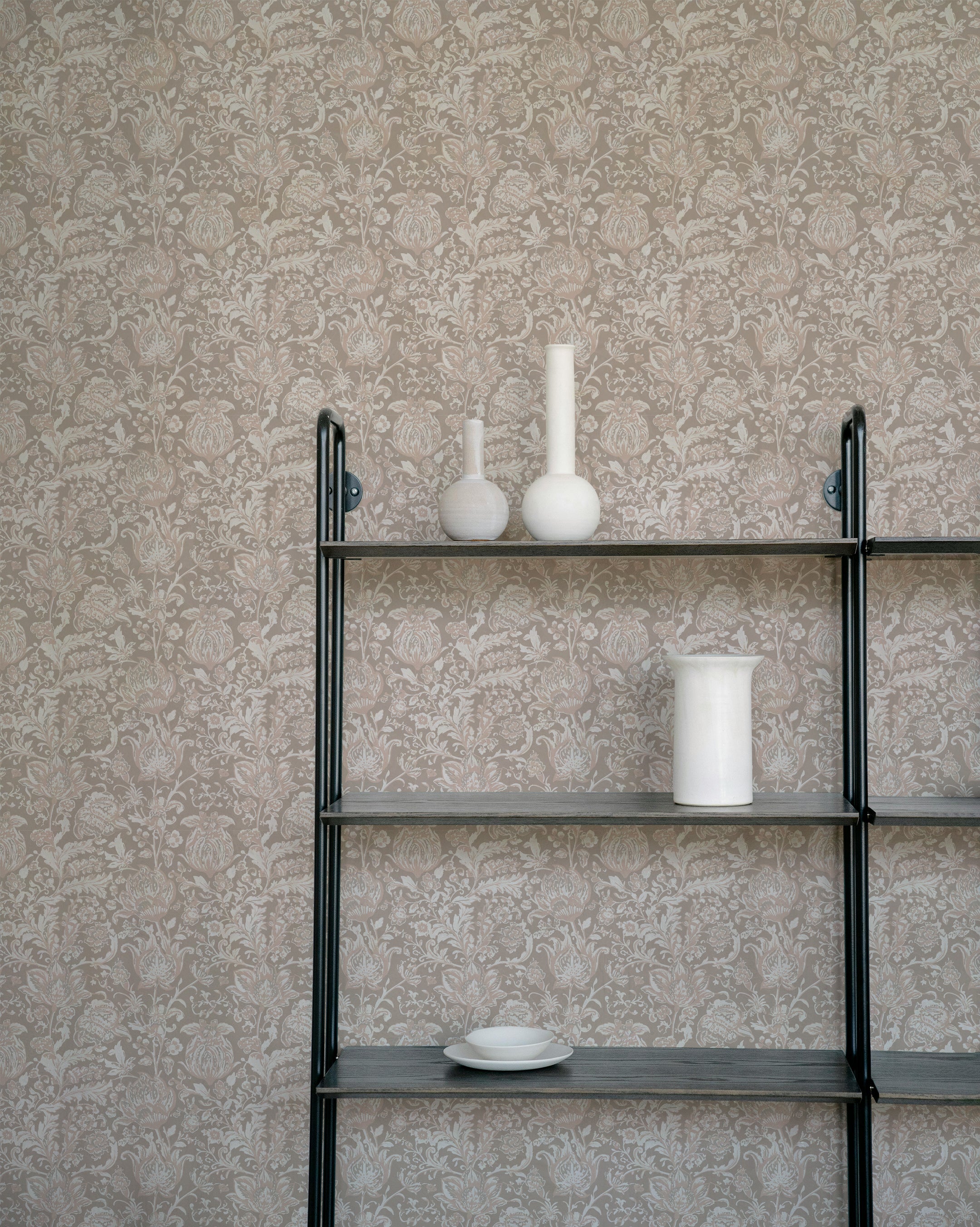 A minimalist shelf displaying white vases and dishes against the Marseilles Wallpaper, which features an elaborate floral pattern in lavender grey. The wallpaper adds a touch of elegance and subtle sophistication to the background.