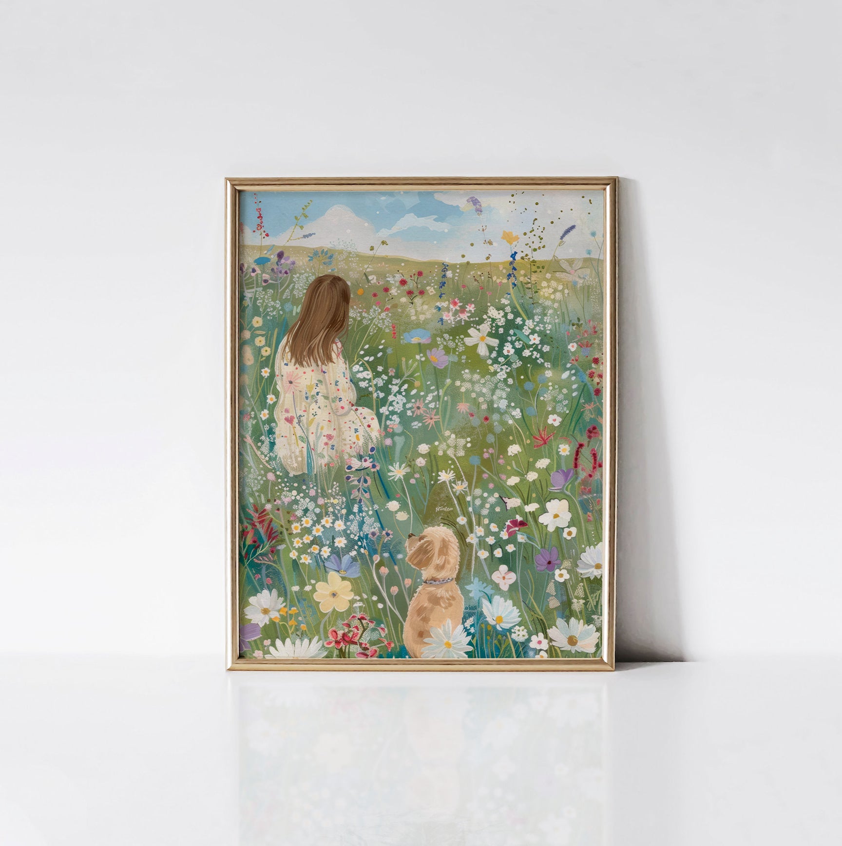The "Field of Dreams" art print displayed in an elegant gold frame, featuring a girl and her dog amidst a colorful wildflower meadow.