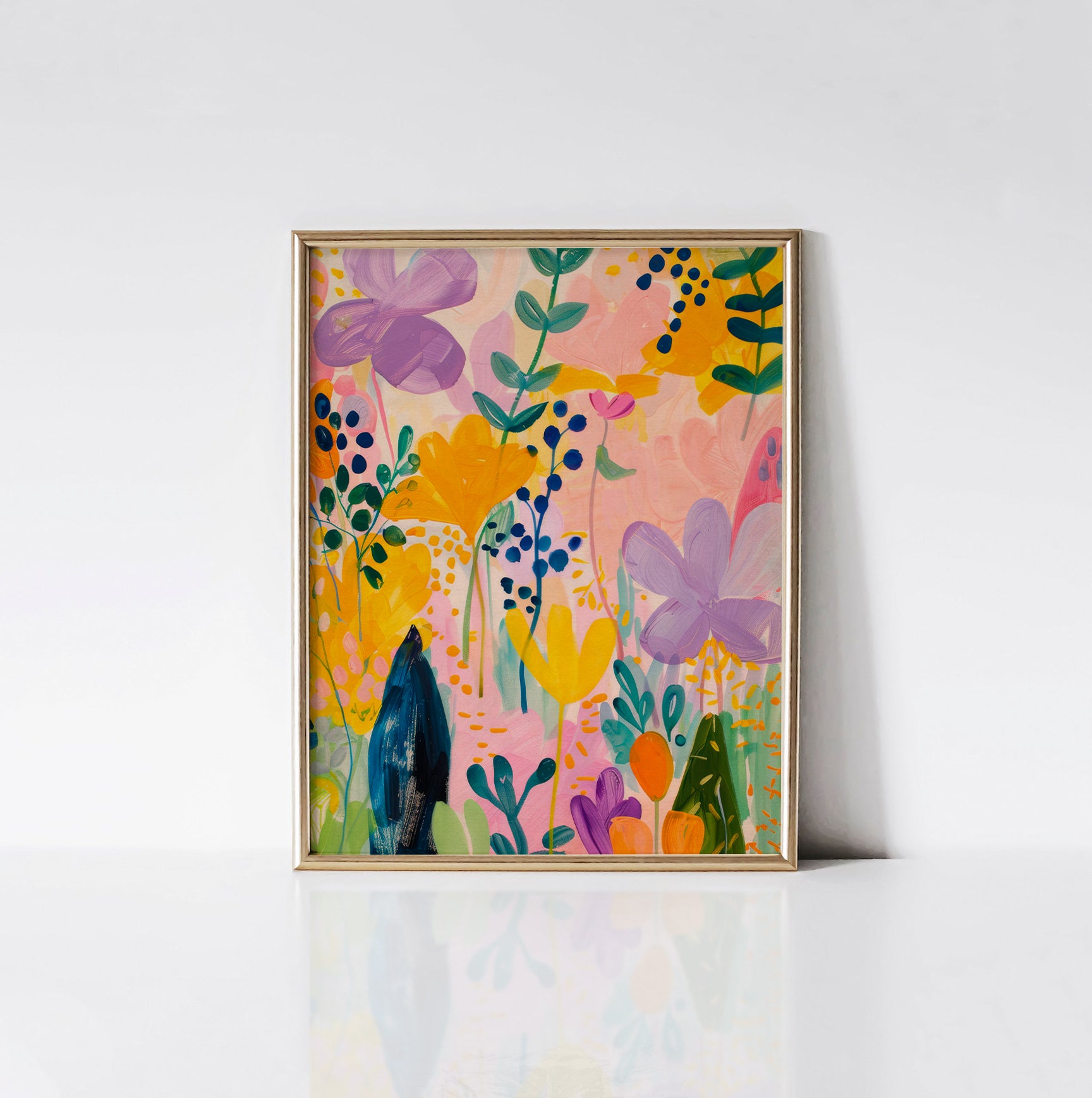 Floral Fantasy Art Print framed in an elegant gold frame, featuring a lively mix of colorful flowers in yellow, purple, and green on a soft pink background.