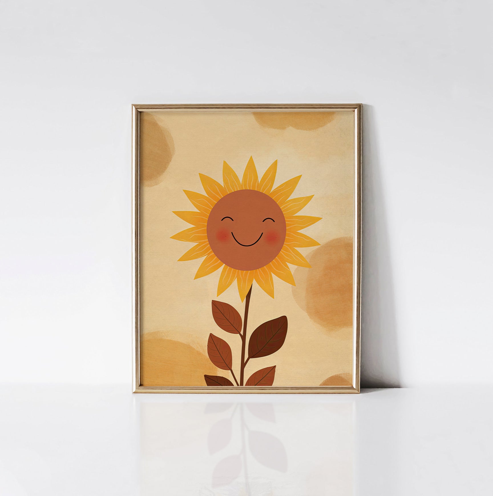 Sunshine Smile art print displayed in a sleek gold frame, featuring a smiling sunflower with radiant yellow petals and warm brown leaves on a soft beige background