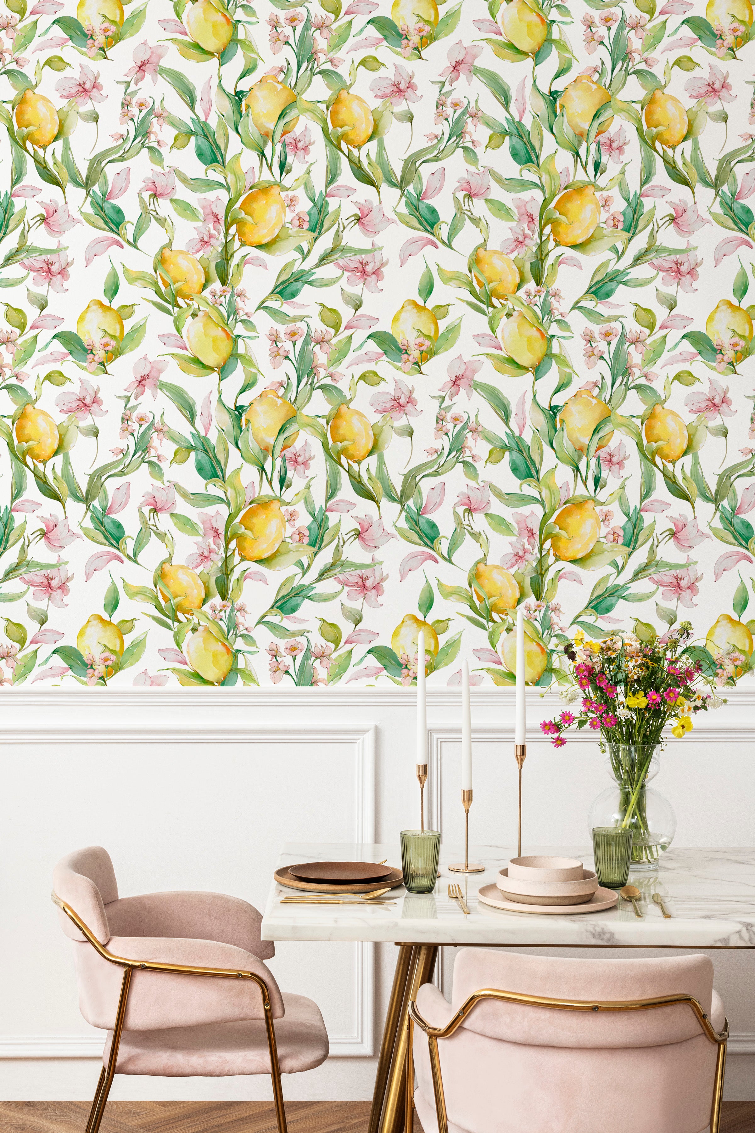 Elegant dining area enhanced by Citrus Blossom Wallpaper, featuring lush yellow lemons and pink blossoms on a vibrant green vine pattern. The fresh and lively wallpaper sets a charming backdrop for the chic marble table and plush pink chairs, creating an inviting space for dining