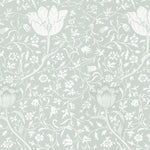 A close-up view of the Fiona Floral Wallpaper in Light Sage, highlighting the intricate botanical design with large tulip-like flowers and various foliage. The wallpaper's soft sage color offers a fresh, soothing backdrop with a touch of elegance.
