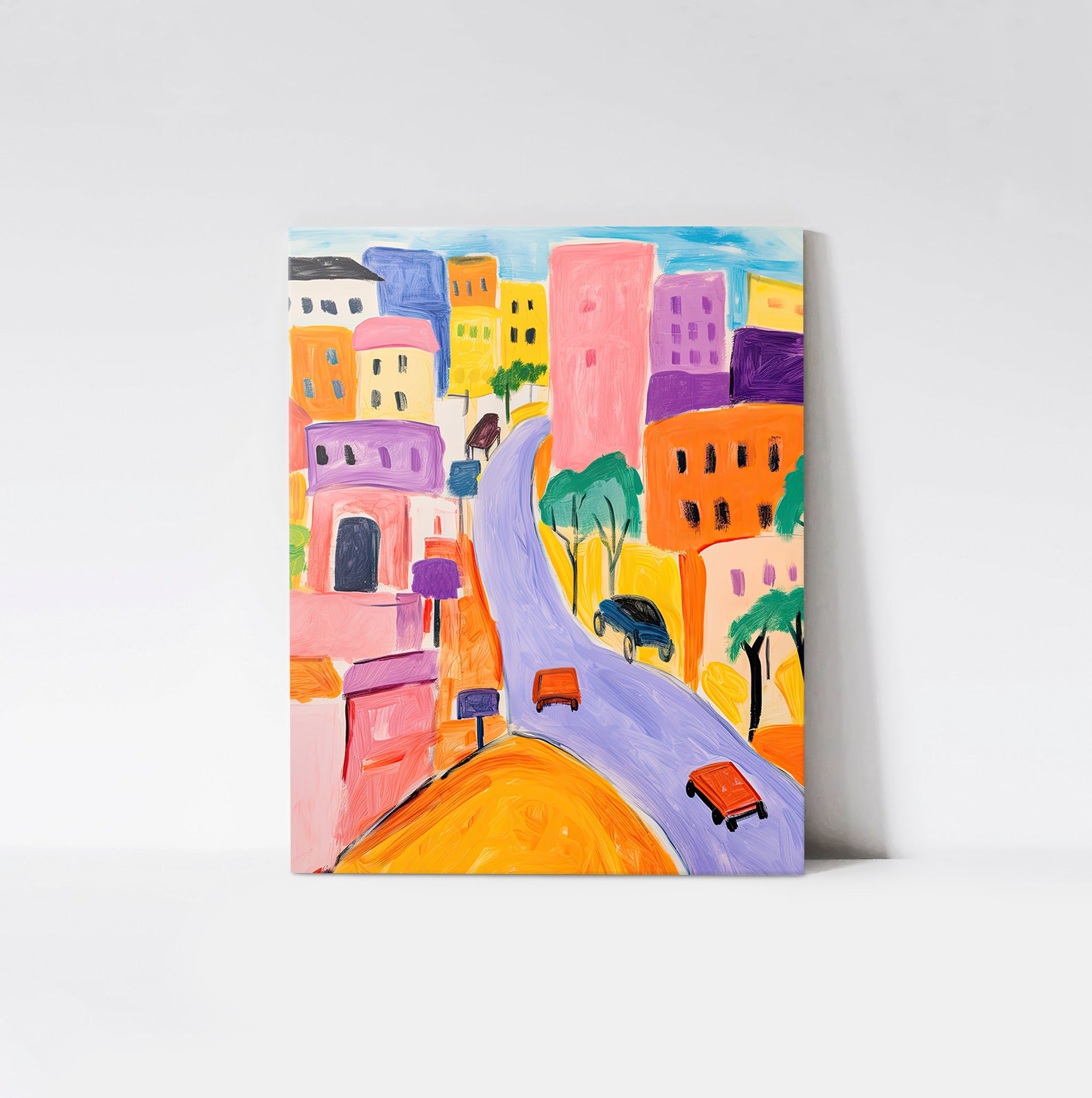 Art print of a lively city scene with vibrant buildings, winding streets, and colorful vehicles, displayed on a wood board