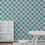 A children's room with walls adorned in Dove Mosaic Wallpaper showcasing a vibrant teal Moroccan tile pattern interspersed with white doves in various poses