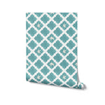 A rolled-up wallpaper featuring a repeating pattern of white doves and teal Moroccan tiles on a square backdrop, conveying a sense of peace and elegance.